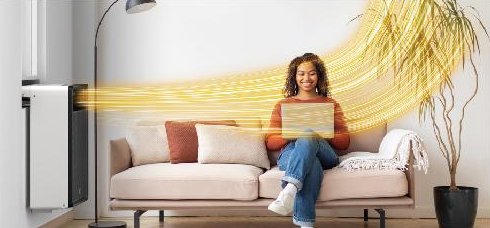 Warm air from a window heat pump reaching a person on a couch
